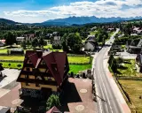 Malownicze tatrzańskie miejscowości z charakterystyczną architekturą i górami w tle.