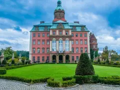 Różowy pałac z wieżą i ogrodem, jeden z wielu pięknych zamków i pałaców Kotliny Kłodzkiej.
