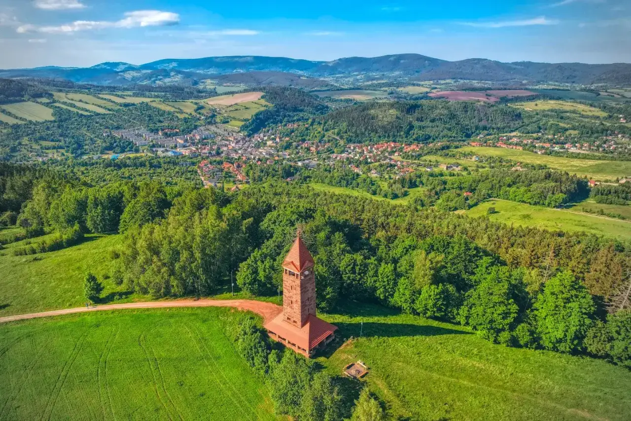 Wieża widokowa na Górze Świętej Anny góruje nad zieloną doliną i miasteczkiem.